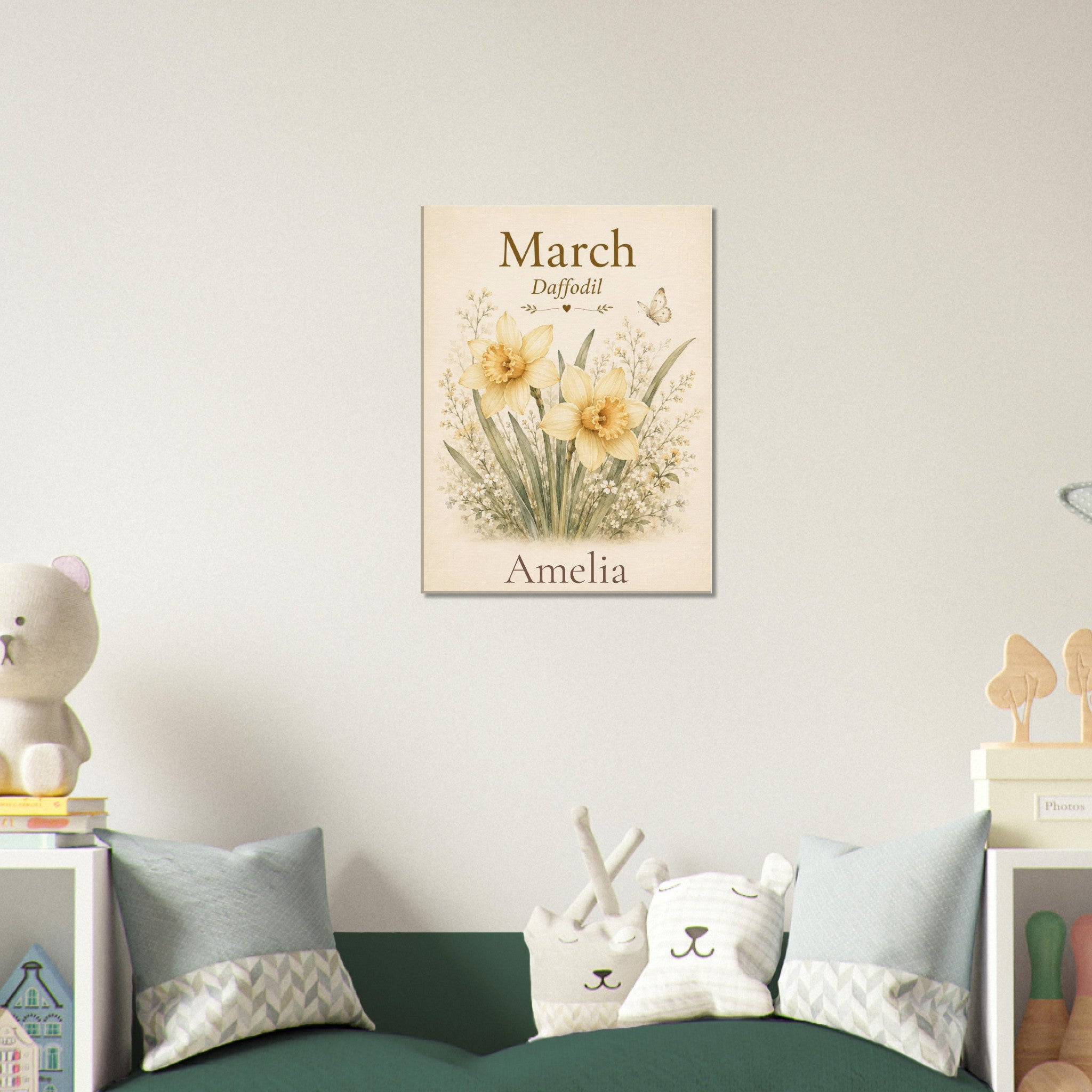 A personalized vertical canvas print featuring yellow daffodils and the text 'March Daffodil Amelia' hanging on a light beige wall above a green sofa with decorative pillows in a styled children's room.