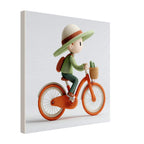 A square canvas wall art print featuring a whimsical 3D-style illustration of a child riding an orange bicycle, shown at a slight angle against a plain white background.
