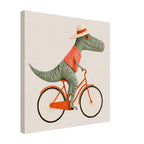 A square canvas wall art print featuring a whimsical illustration of a green dinosaur riding an orange bicycle, wearing a cream-colored straw hat with an orange band. The canvas is shown at an angle to display its 3D depth on a clean white background.
