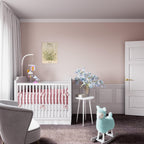 A styled nursery room featuring a white wooden baby crib with pink bedding, a small white side table with blue flowers, a plush light blue rocking llama, and a pink wall with wainscoting and a framed fox portrait.