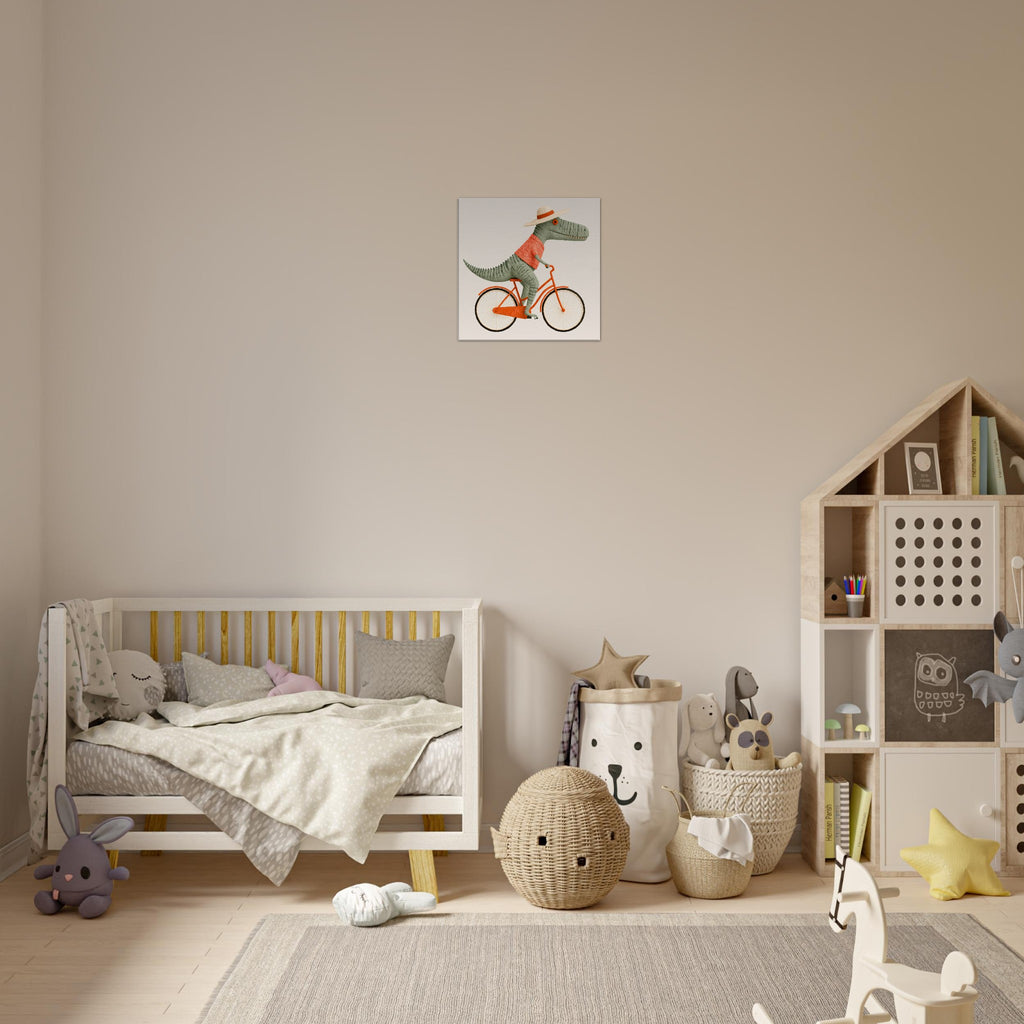 A styled children's bedroom featuring a square wall art print of a green dinosaur riding an orange bicycle. The room includes a white wooden toddler bed, a wooden house-shaped bookshelf, and neutral-toned decor on a light wood floor.