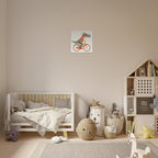 A styled children's bedroom featuring a square wall art print of a green dinosaur riding an orange bicycle. The room includes a white wooden toddler bed, a wooden house-shaped bookshelf, and neutral-toned decor on a light wood floor.