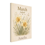 A vertical canvas print featuring a vintage-style illustration of yellow daffodils with green stems on a warm cream background. The top of the print reads 'March Daffodil' and the bottom reads 'Amelia', suggesting a personalized monthly wall calendar design.