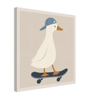 A square canvas wall art print featuring a stylized white duck wearing a blue cap and standing on a dark skateboard against a warm beige background, shown at a slight angle with a white border.