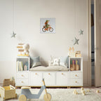 A styled children's bedroom corner featuring a white storage bench with open shelves and drawers, decorated with toys, pillows, and books. A small framed print of a child riding a bicycle hangs on the wall above, with hanging star decorations and a wooden toy cart in the foreground on a white rug.