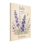 A vertical canvas print featuring a watercolor-style floral design with purple and blue flowers on a cream background, with the text 'July', 'Larkspur', and 'Emma'.